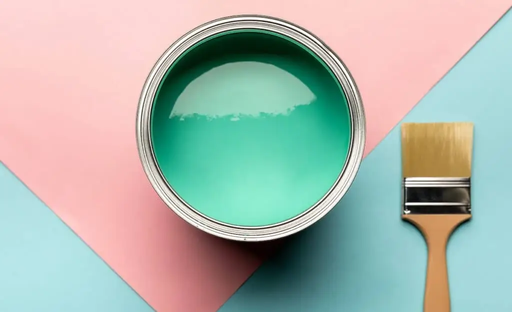 A can of interior latex paint with a paintbrush